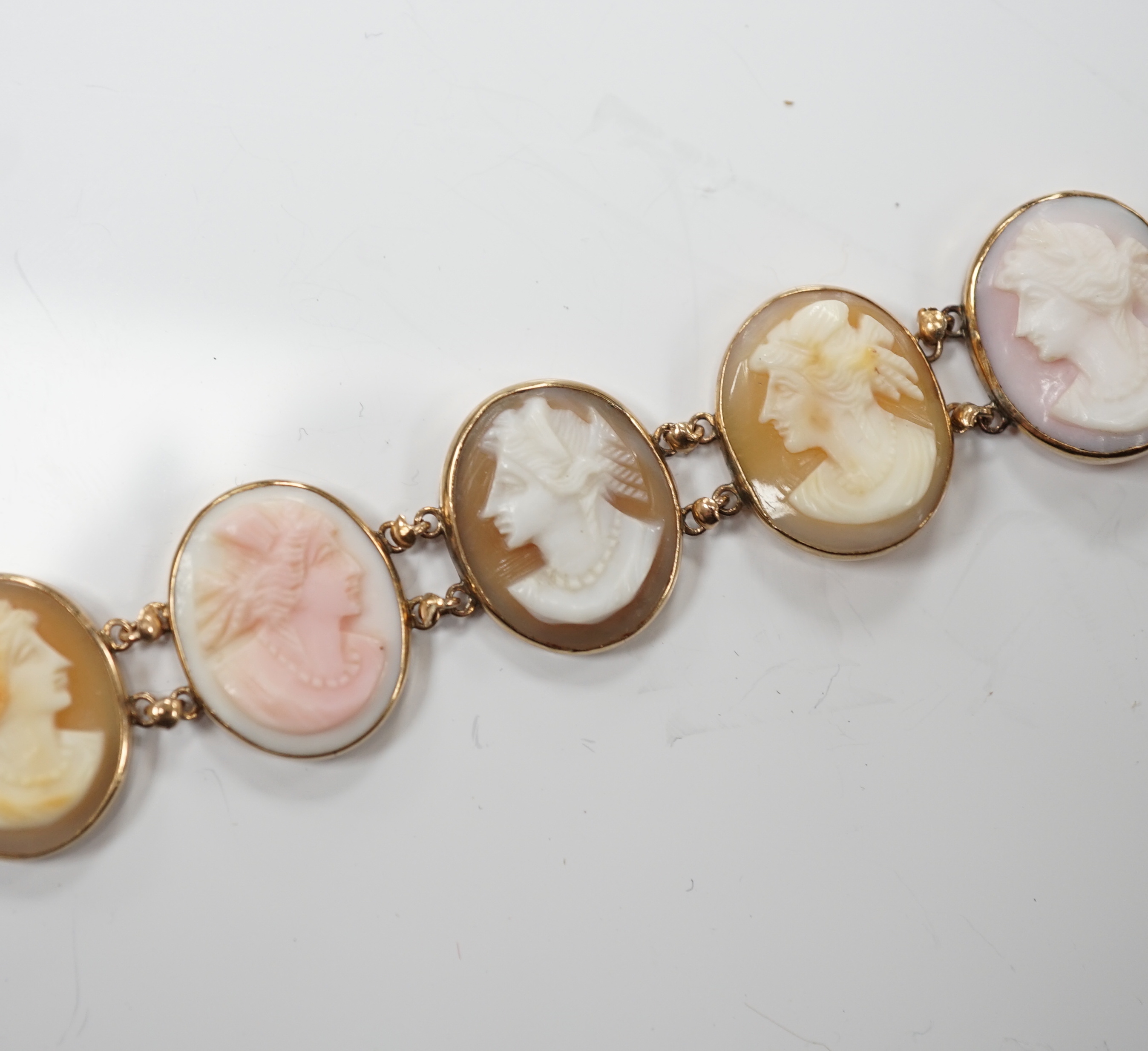 A yellow metal mounted ten stone oval cameo shell set bracelet, each carved with bust of a lady to sinister, 16cm, gross weight 13.9 grams.